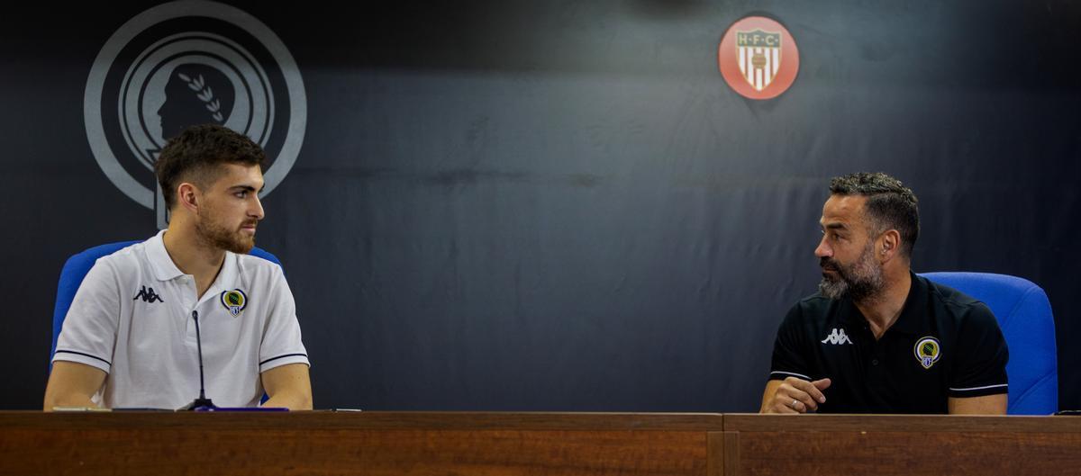 Agustín Coscia y Paco Peña conversan mientras los periodistan ocupan su lugar en la sala de prensa.