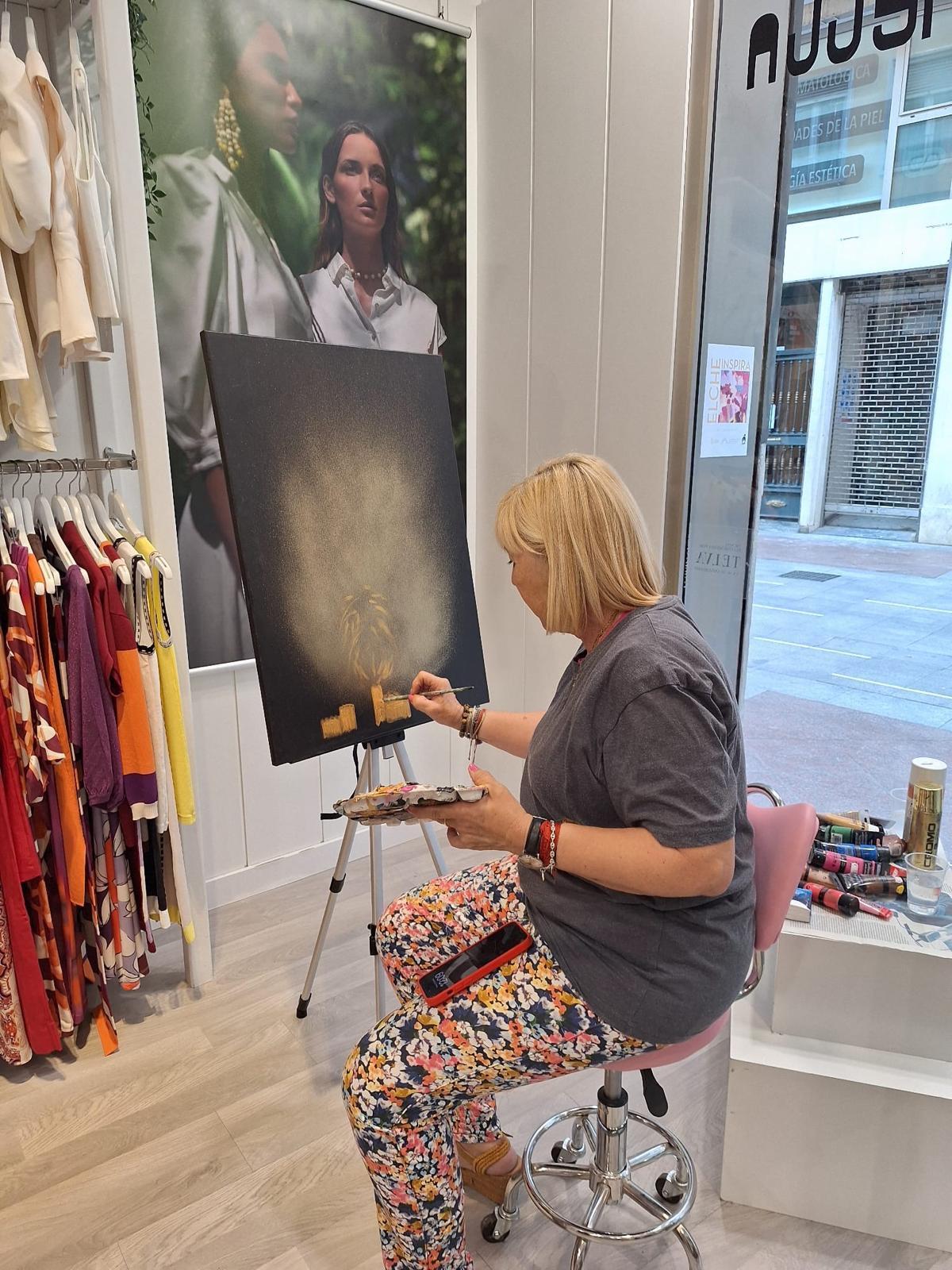La pintora realiza su obra en directo en la tienda Conchetta de Elche