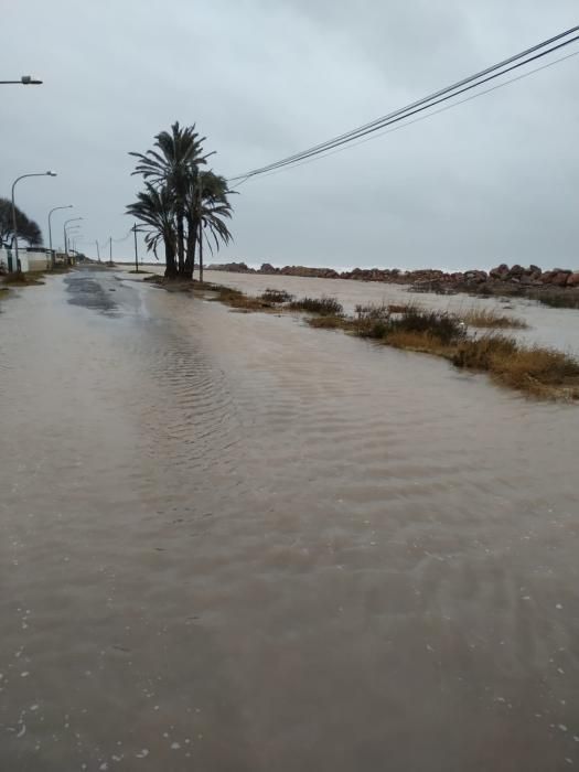 Agua y arena invaden el paseo del Puig.