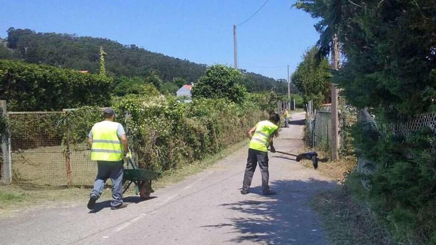 Una brigada de operarios limpiando los accesos a las playas en O Hío. // G.Núñez