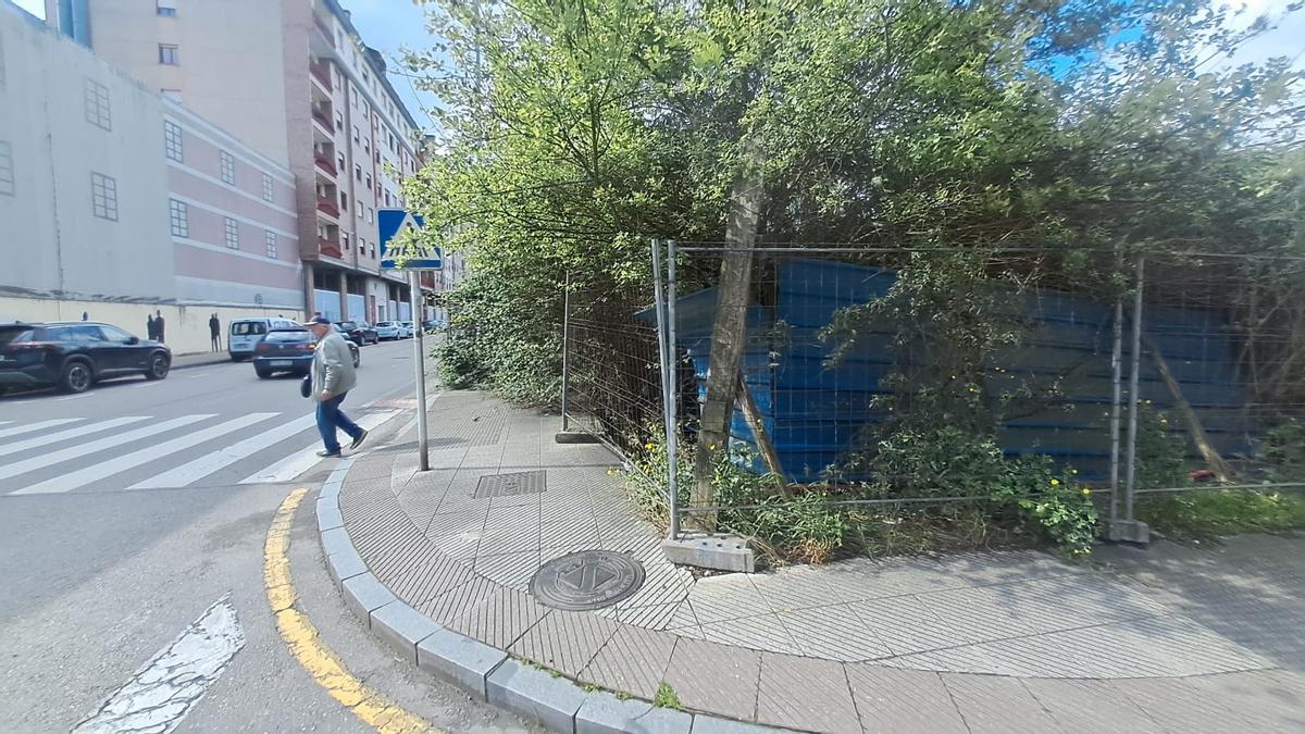 Un vecino, cruzando de calle al no poder transitar por la acera anexa a la parcela abandonada.