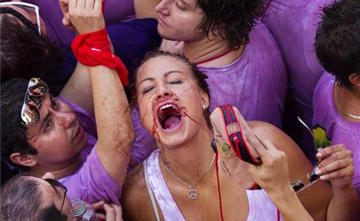 Diverses persones es reguen amb vi l’inici de les festes del patró de Pamplona.