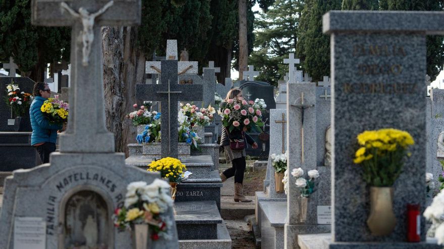 Dos mujeres llevan flores al cementerio este pasado 31 de octubre. | Jose Luis Fernández