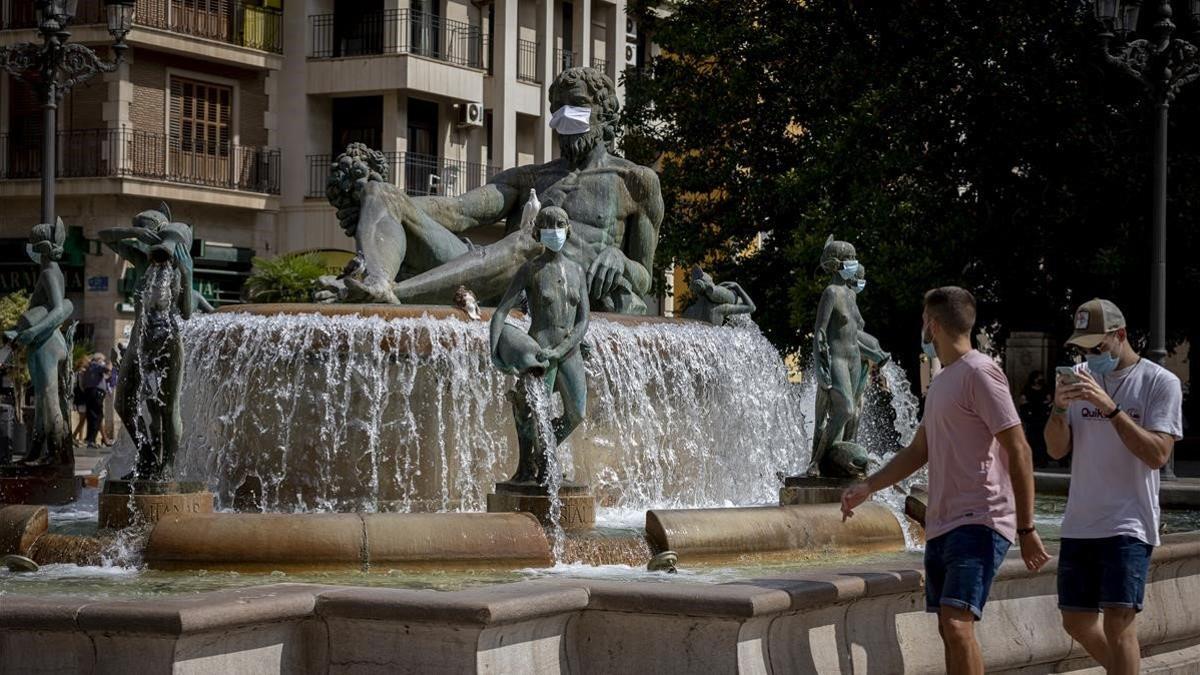 La fuente del Turia, en la plaza de la Virgen de València, con las estatuas con mascarilla.