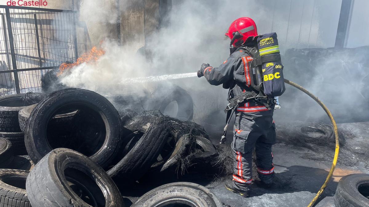 Un efectivo de los bomberos sofoca llamas en neumáticos en Onda.