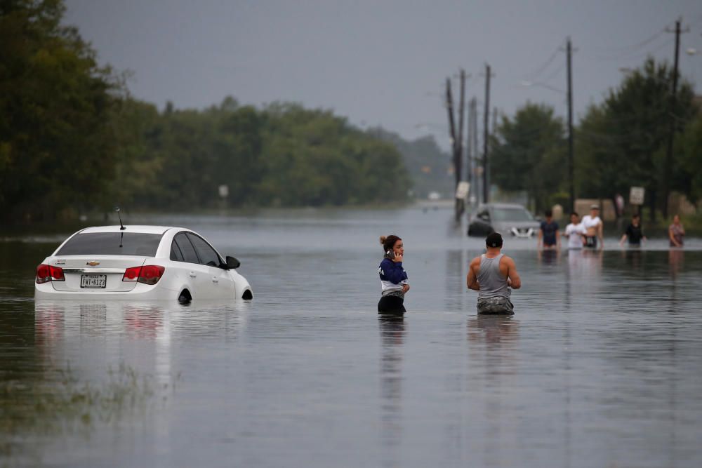 Residentes caminando por las aguas de la tormenta tropical Harvey.