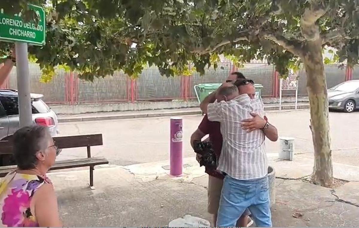 Lorenzo Delgado abraza al alcalde de Villanueva, tras descubrir su nombre en la placa para nombrar la plaza.