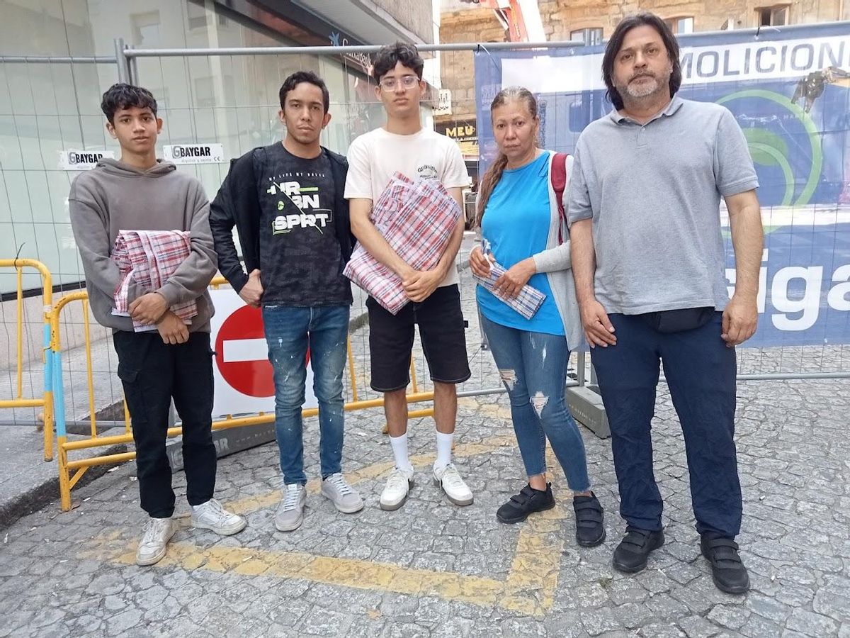 Residentes en la primera planta del edificio esperan con sus bolsas para entrar a sus viviendas.