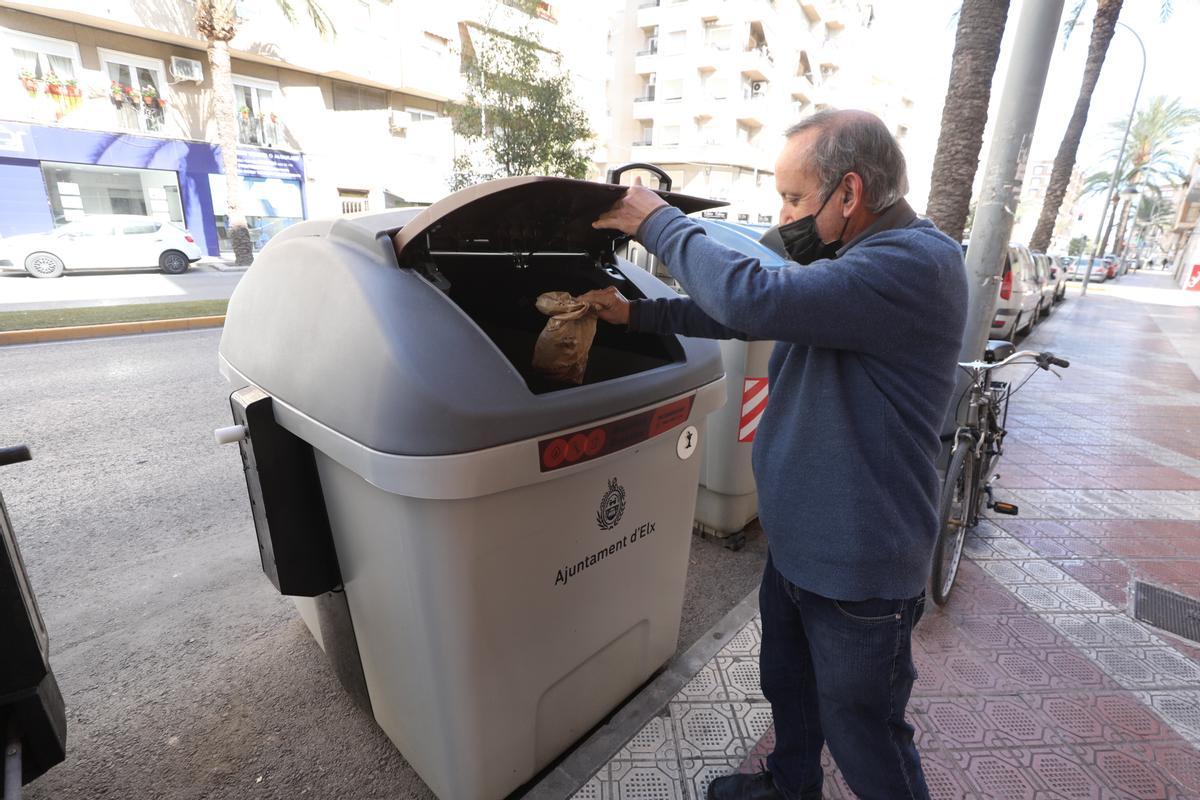 Un ciudadano utiliza el contenedor marrón en la calle Pedro Juan Perpiñán