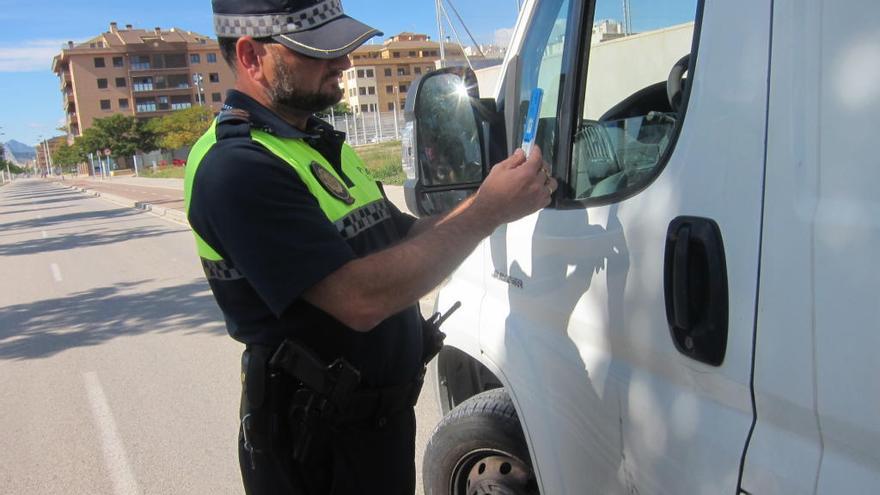 Un agente realizando el test de alcoholemia a un conductor