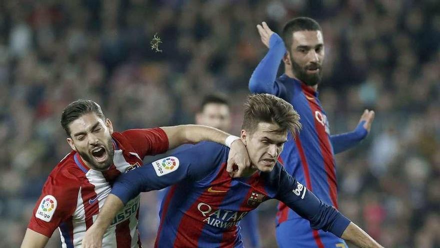 Denis Suárez intenta proteger el balón del acoso de Carrasco. // Andreu Dalmau