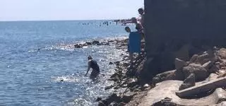 El suplicio de bañarse entre escombros en la playa de Dénia
