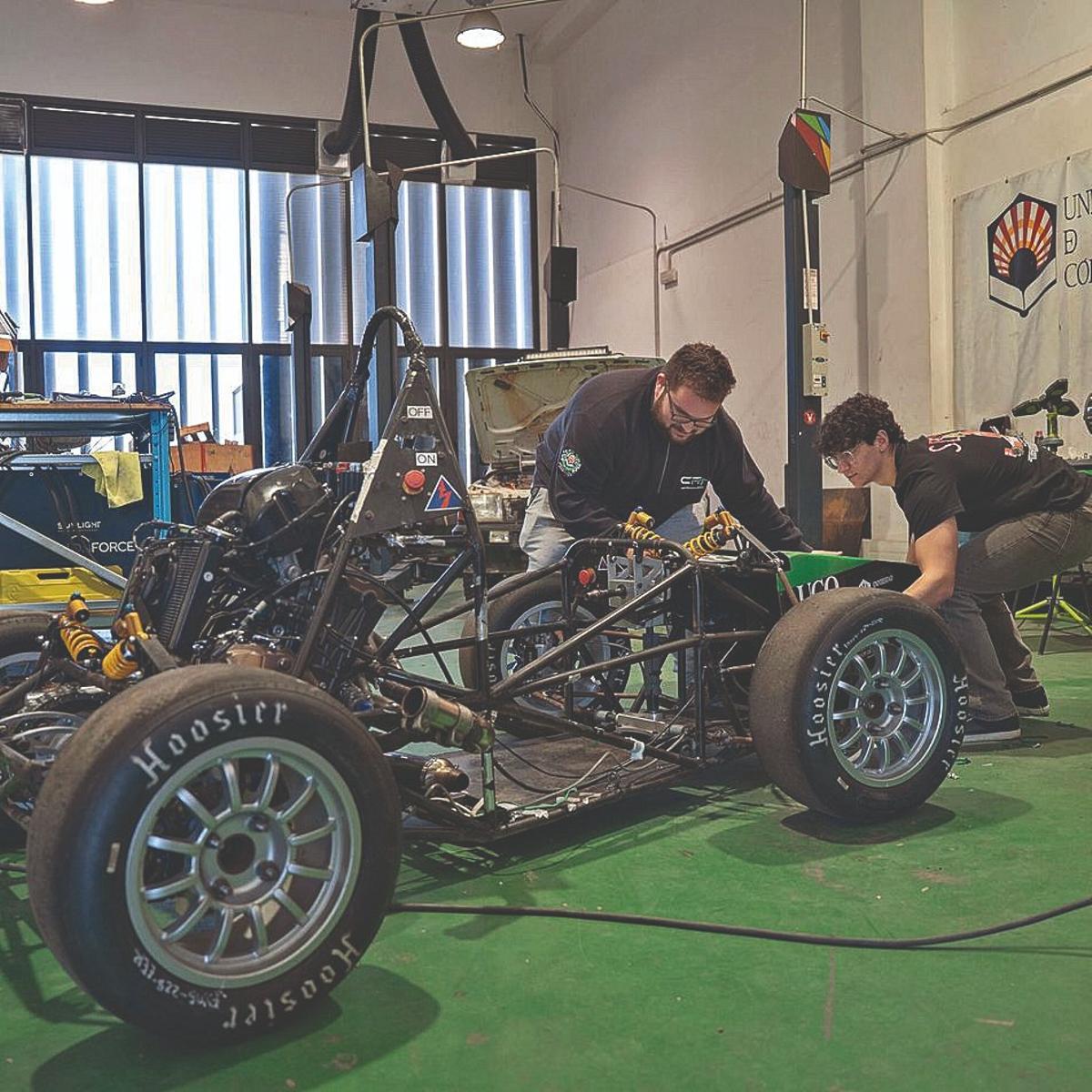 Dos jóvenes trabajan en un prototipo de monoplaza utilizando los espacios disponibles para el desarrollo de proyectos.