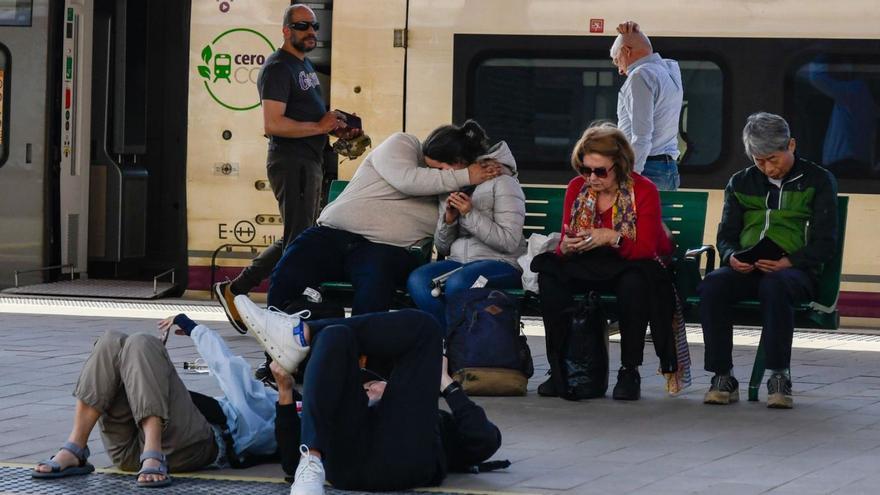 Viajeros de los trenes Madrid-Vigo en la estación de Zamora, cogiendo los autobuses de vuelta a Galicia y un pequeño pasajero es asistido por un trabajador de Cruz Roja en el albergue provisional instalado en el recinto ferial Ifeza. | MIGUEL ÁNGEL LORENZO