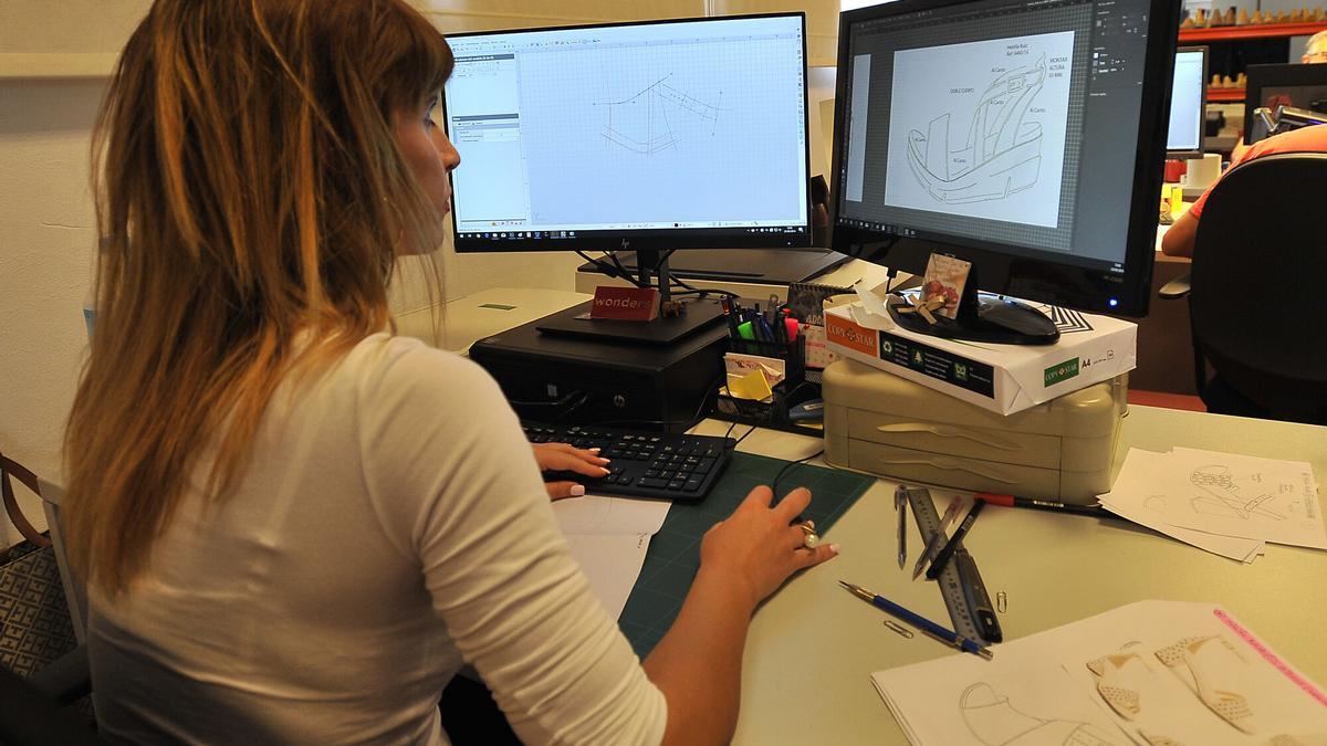 Una trabajadora, delante del ordenador de una oficina.