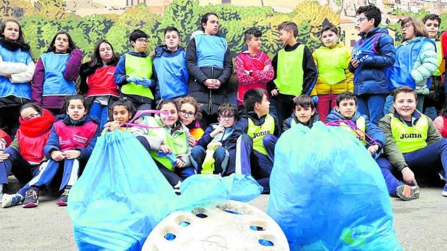 Un grupo de niños del colegio Santísima Trinidad posan con toda la basura recogida en una de sus salidas a la zona del río. | Colegio Santísima Trinidad