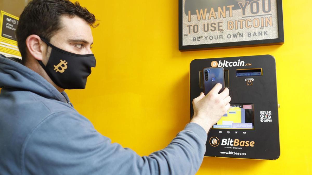 Un usuari fa servir el caixer de bitcoins que hi ha a Girona en una fotografia d’arxiu | ANIOL RESCLOSA