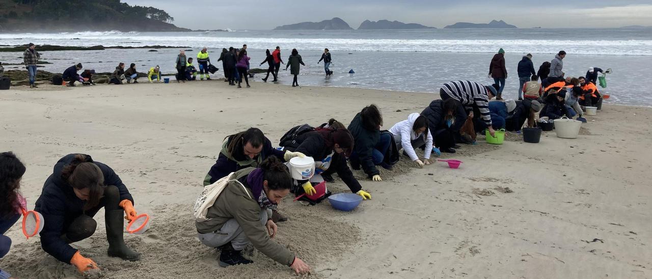 Voluntarios recogen pellets en la playa de Patos tras el vertido del &quot;Toconao&quot;.