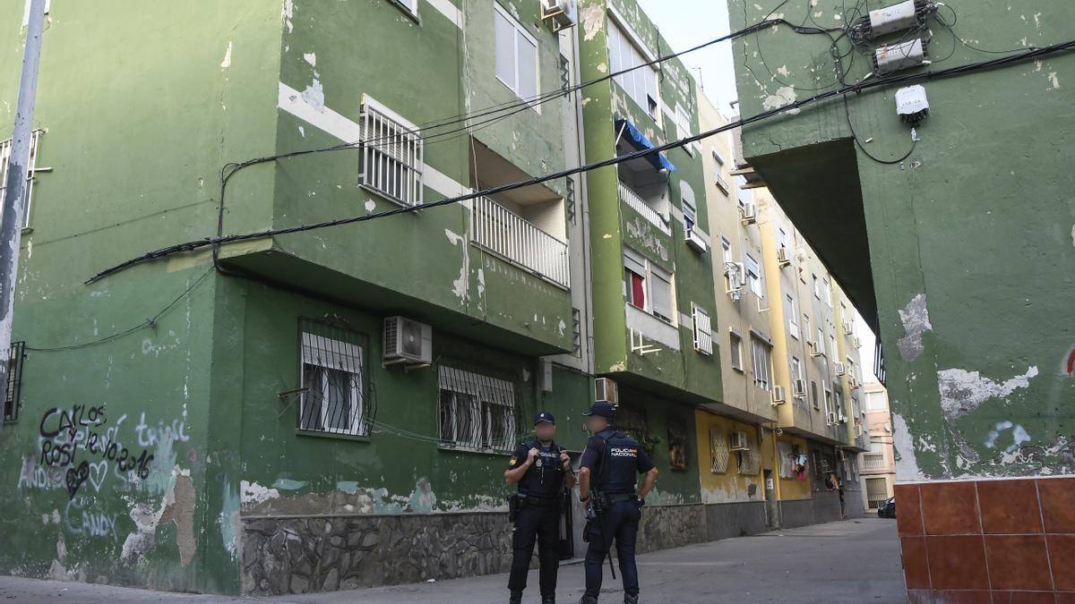 Miembros de la Policía Nacional vigilan uan vivienda donde habían asesinado a una persona