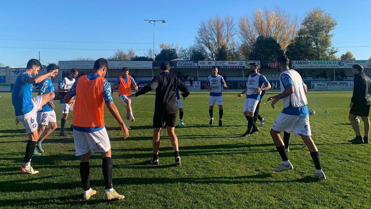 Los jugadores del Coria calientan antes de un partido en La Isla.