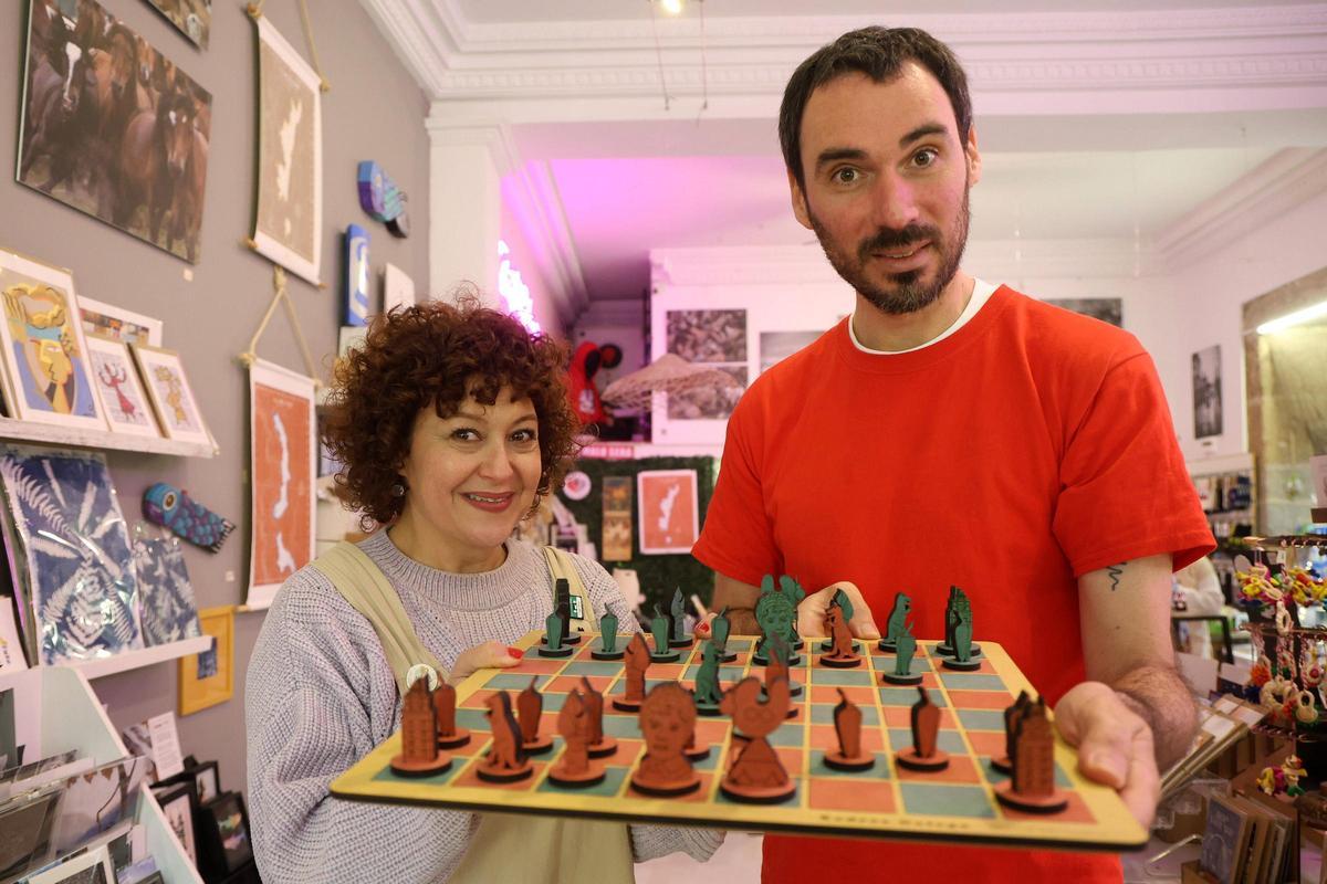 David Rodríguez muestra su ajedrez junto a la propietaria de la tienda "Amo Galicia".