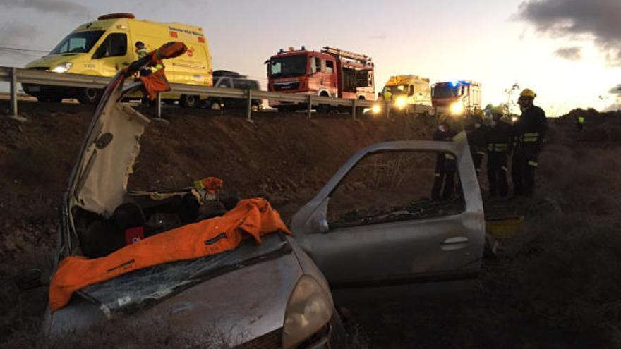 El turismo accidentado ayer en Tinajo, junto a los bomberos, ambulancias del SUC, Guardia Civil y Policía Local.