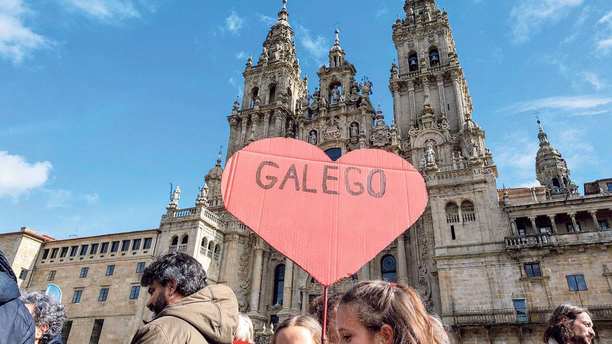 Manifestantes no Obradoiro cunha pancarta en defensa do galego. |