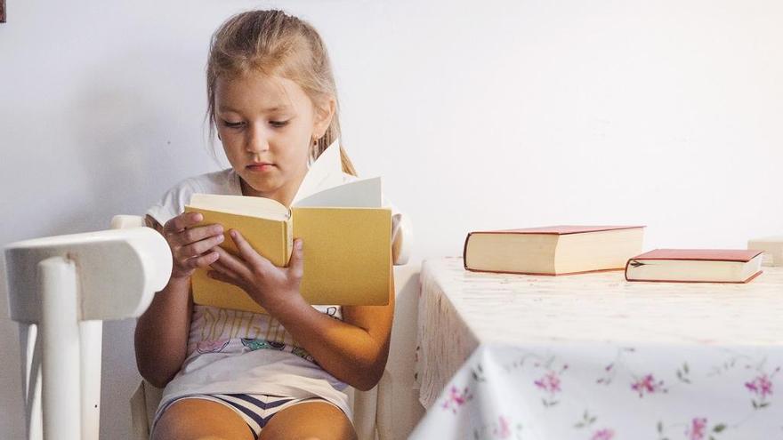 Una niña leyendo un libro.