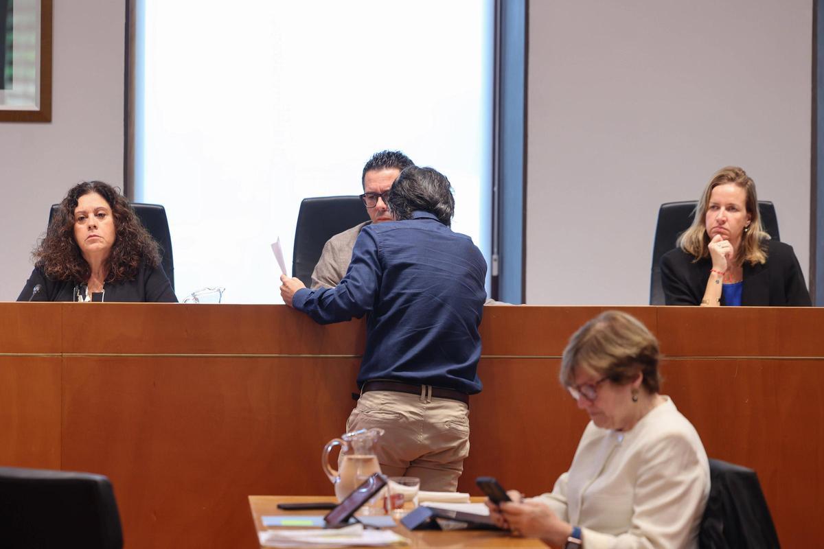 El secretario se acerca al alcalde Rafael Triguero durante el pleno municipal extraordinario de este jueves.