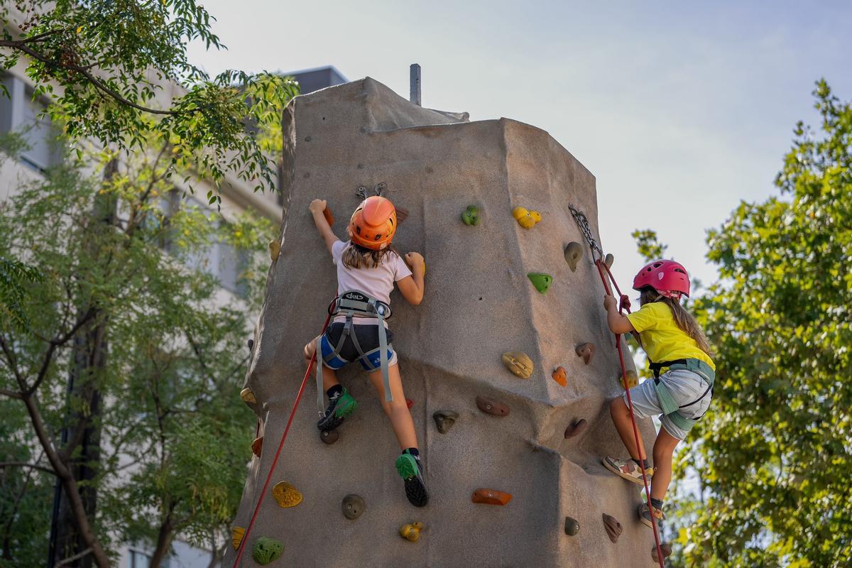 Dos niñas suben por un rocódromo