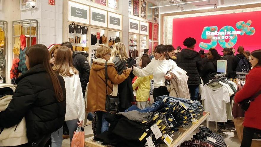 Clientes comprando en las presentes rebajas de invierno en un comercio de Vigo. // Marta G. Brea