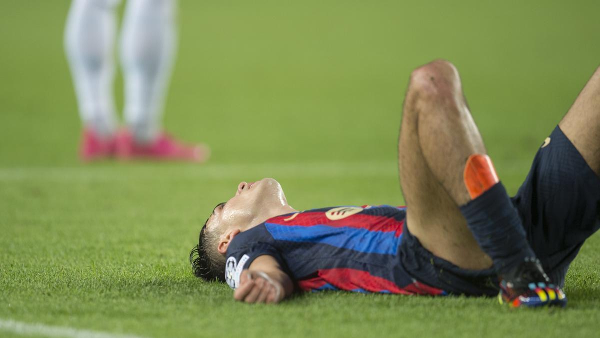 Pedri exhausto en el césped del Camp Nou durante el partido