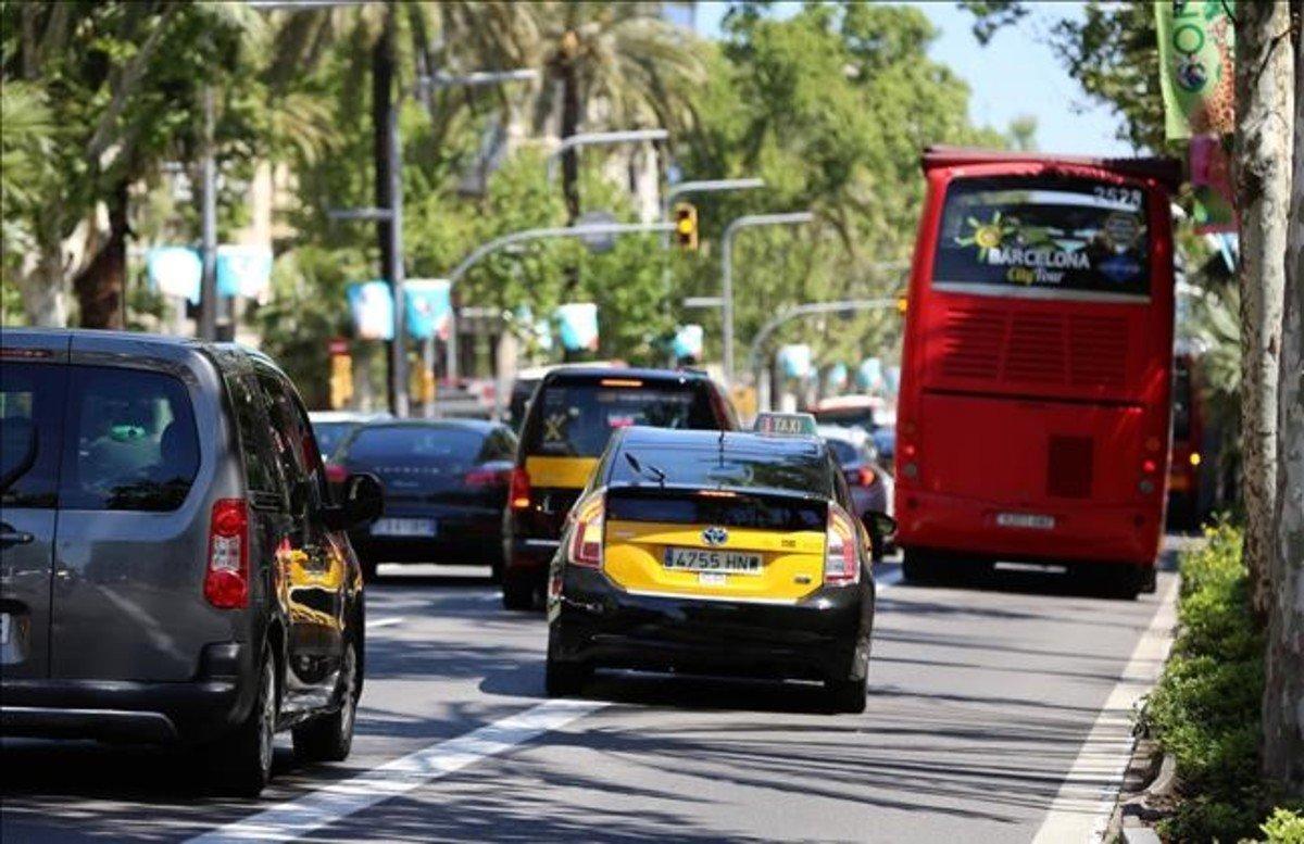 Un taxi ningunea la línea continua para avanzar a un autobús en la Diagonal.