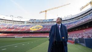 Joan Laporta, candidato a la presidencia del FC Barcelona en las elecciones del próximo domingo, observa desde el césped la gradería del Camp Nou todavía con grúas, mientras espera para hacerse la fotografía con el otro candidato, Víctor Font. 
