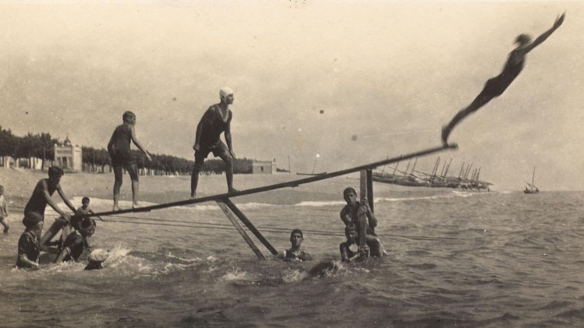 Jóvenes practicando saltos de trampolín en la zona de baños de Calella, en 1916.