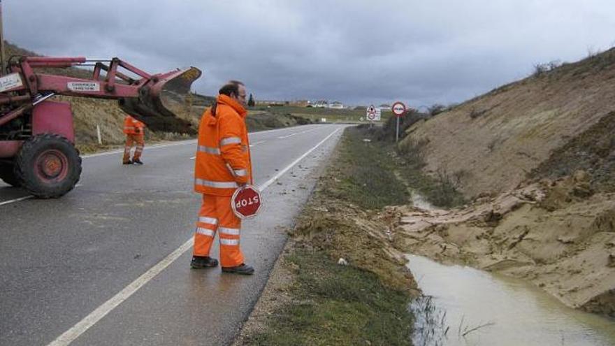 Trabajadores de Fomento retiran la tierra caída en las cunetas entre Santovenia y Bretó.