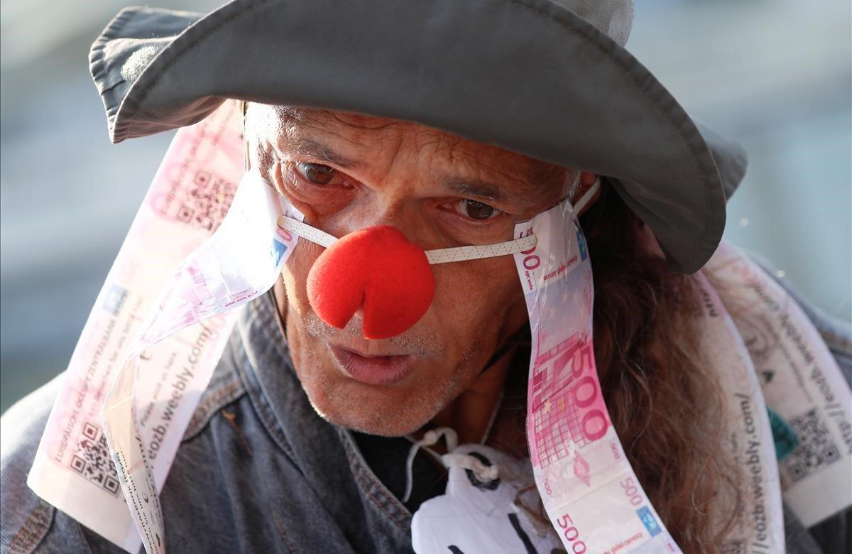 Un manifestante protesta contra el banco comercial más grande de Alemania, el Deutsche Bank, antes de la reunión anual de accionistas del banco en Frankfurt, Alemania.