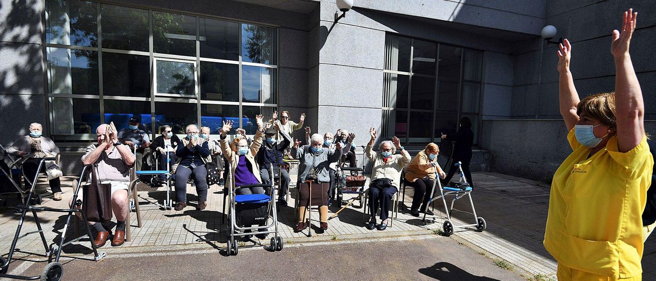 Mayores de la residencia pública de Campolongo hacen gimnasia en el exterior.