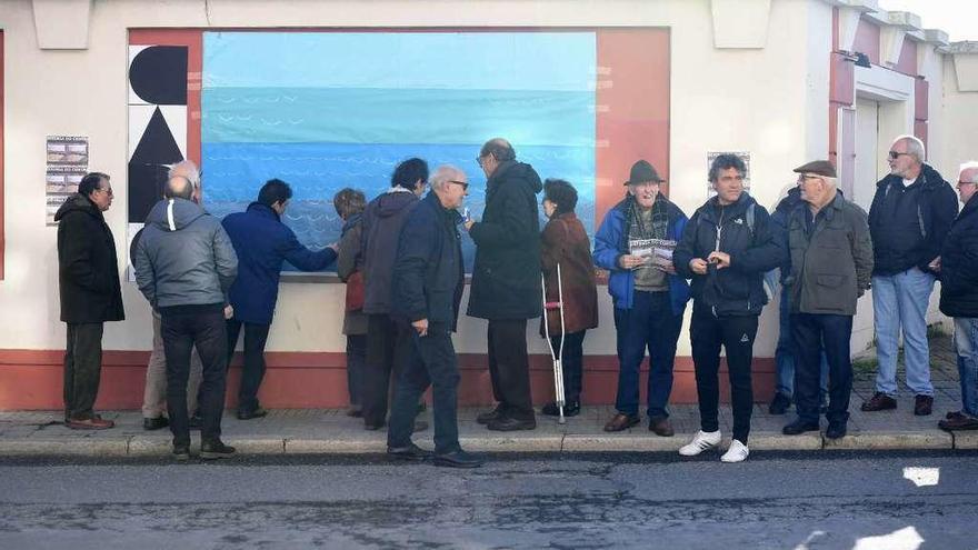 Asistentes al acto de Defensa do Común dibujan olas en el mural.