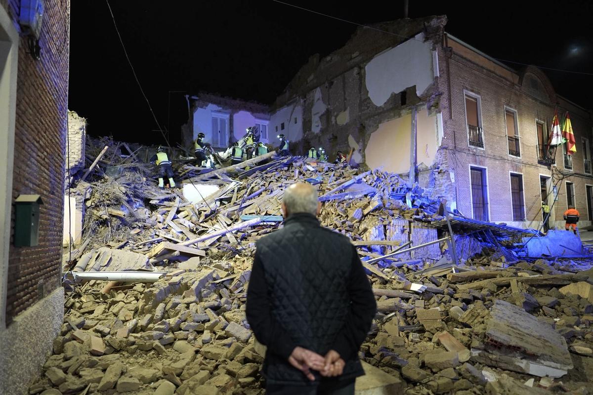 Un hombre observa el edificio derrumbado.
