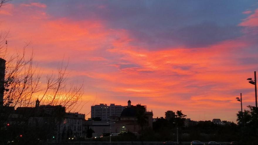 Cielo rojizo al amanecer sobre el puente de Serranos en València.