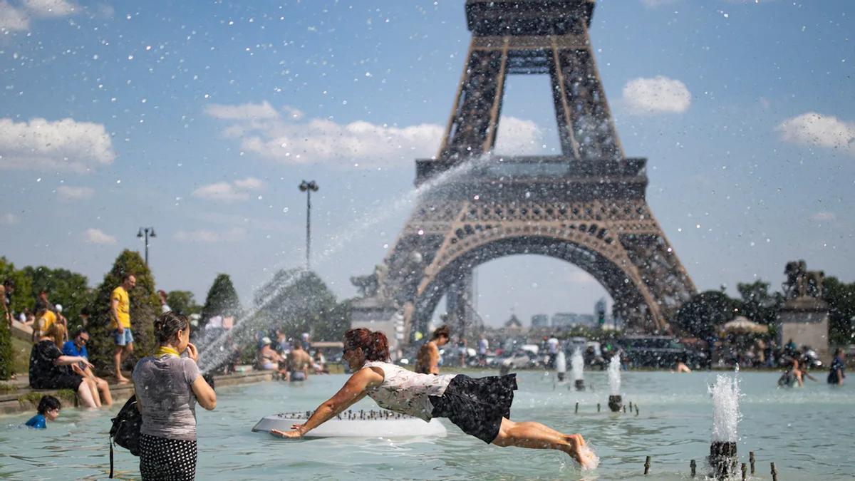 Varias personas se refrescan en la fuente de la plaza del Trocadero, frente a la Torre Eiffel, durante la ola de calor de 2019.