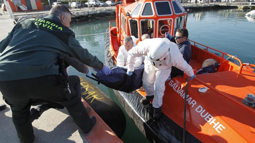 Agentes de la Guardia Civil y de Salvamento Marítimo, en el puerto de Algeciras, con uno de los cinco cadáveres de inmigrantes que han sido encontrados en las últimas horas en las costas de Algeciras y Tarifa.