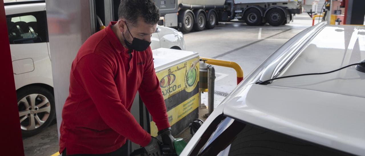 Un operario llena un depósito de un coche en una gasolinera de València.