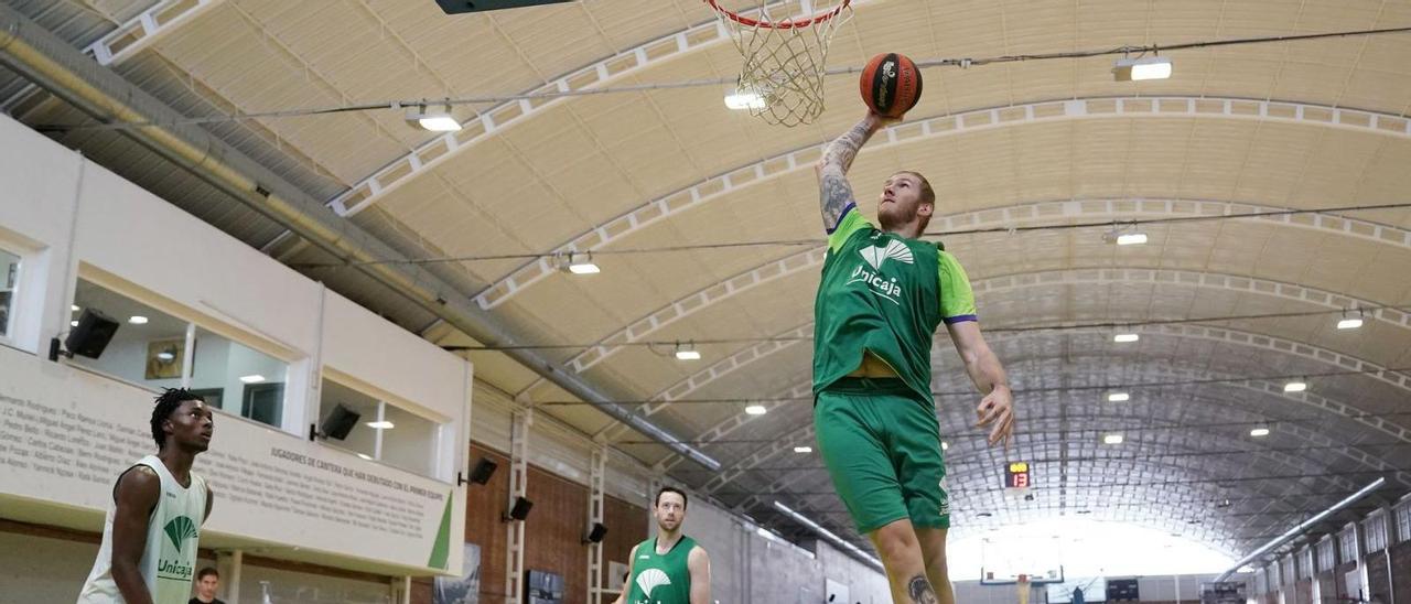 Dylan Osetkowski machaca el aro en una imagen de un entrenamiento de esta pasada semana en Los Guindos de los jugadores del Unicaja. | UNICAJAB/FOTOPRESS