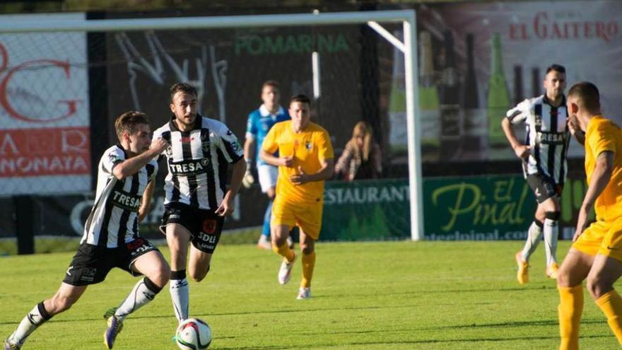 Álex conduce el balón acompañado por Adrián Llano.