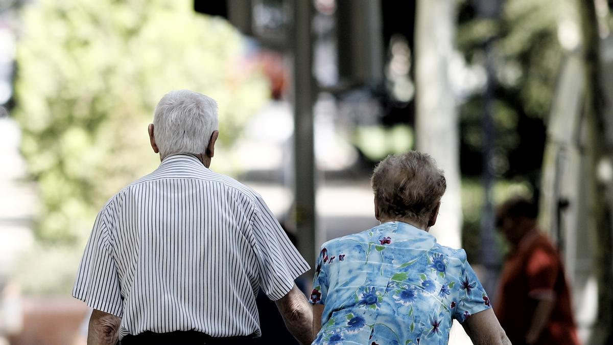 Una pareja de pensionistas paseando por un parque de Madrid.