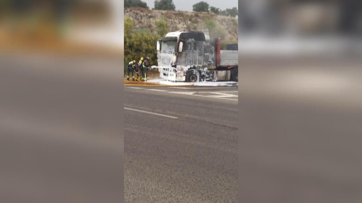 Los bomberos extinguen el fuego que ha calcinado un tráiler en Lucena.