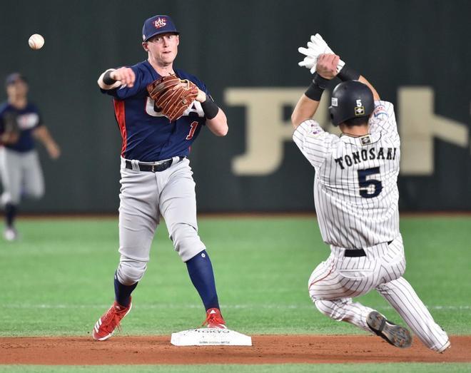 El campocorto estadounidense Jacob Cronenworth (L) hace una doble jugada frente al primer corredor de Japón Shuta Tonosaki (R) durante el partido de béisbol WBSC Premier 12 Super Round entre Japón y EE. UU., En el Tokyo Dome de Tokio.