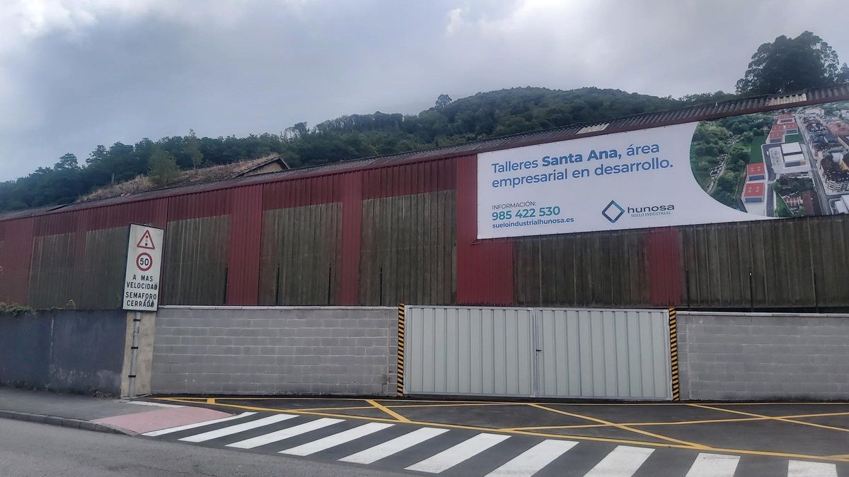 Una de las naves de los Talleres de Santa Ana, con un anuncio sobre el proyecto del área empresarial.